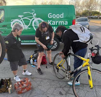 Good Karma Bikes volunteers tuning a bicycle beside the nonprofit’s van